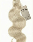 Wavy blonde tape-in human hair extensions with an OGB brand tag. 